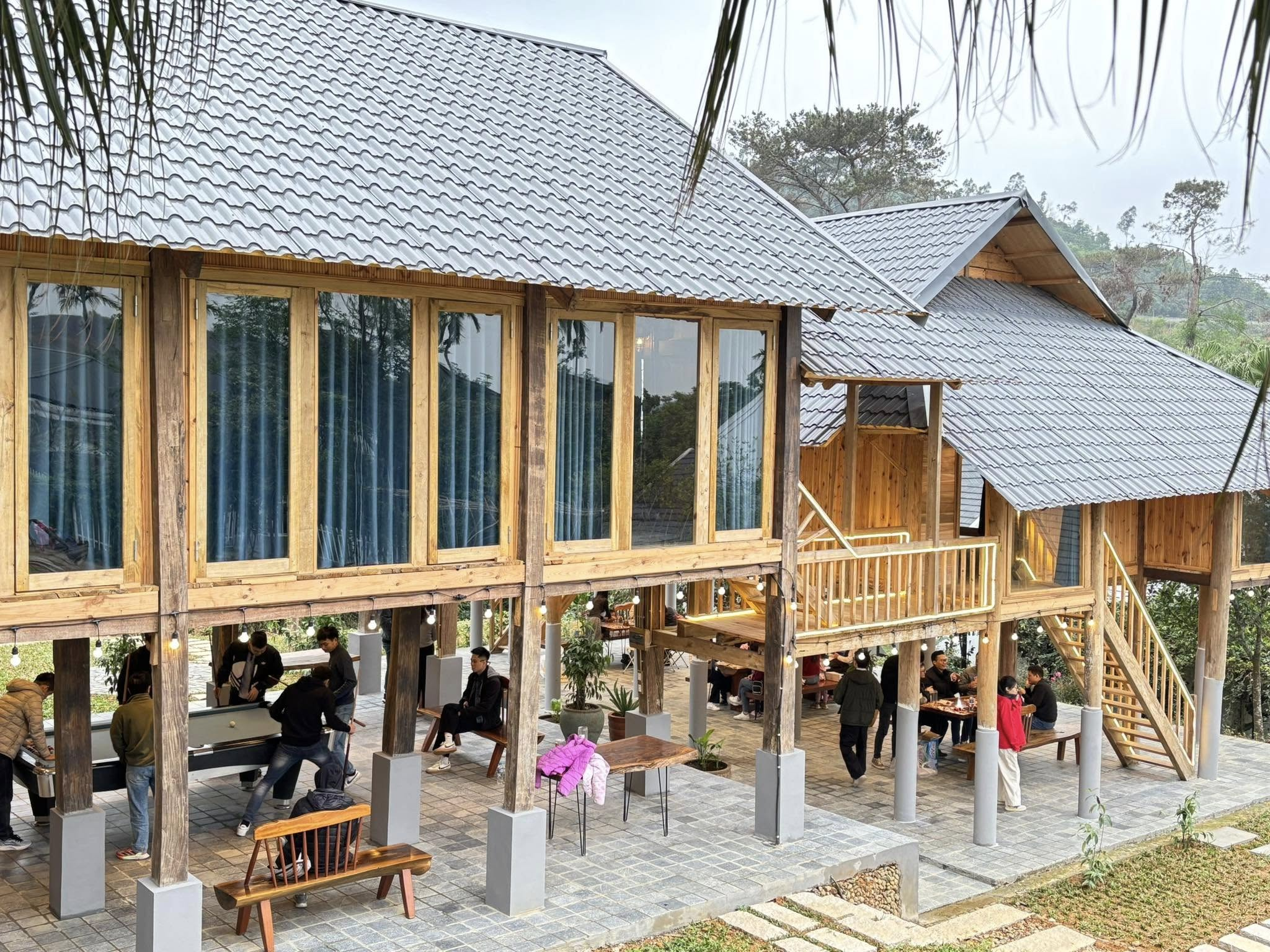 Không gian nhà gỗ mái ngói tại Rose Villas, giữa khung cảnh nhiều cây xanh