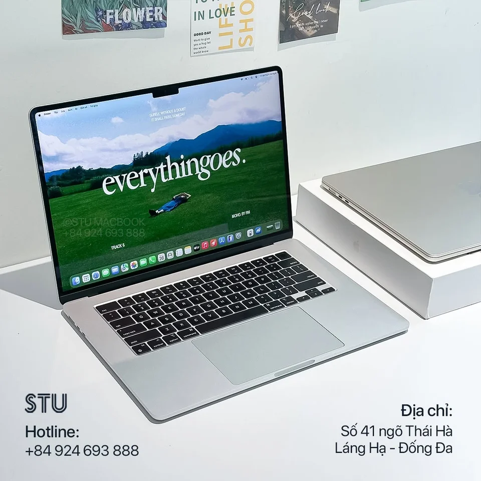 MacBook màu bạc trên bàn cùng logo STU Macbook